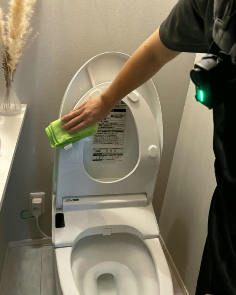 トイレの便座まわりを拭くスタッフ