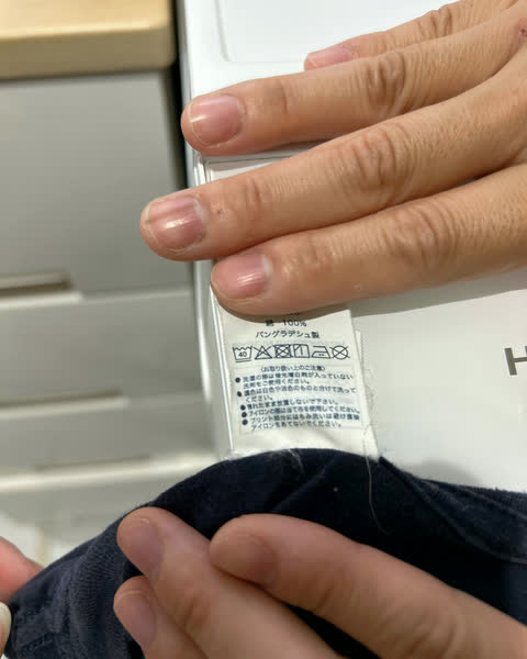 衣類の洗濯表示を確認している手元